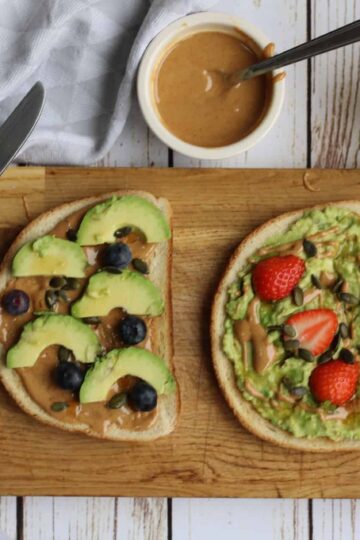 Healthy vegan avocado toast with peanut butter and fresh fruit toppings.