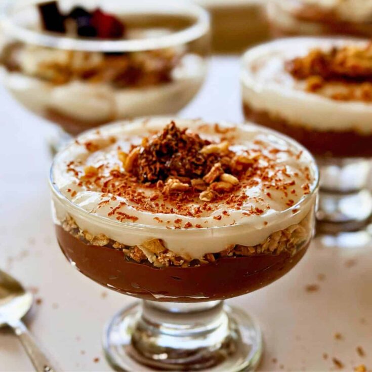 Vegan chocolate mousse served in a glass with whipped coconut cream and crushed nuts. Perfect for a.