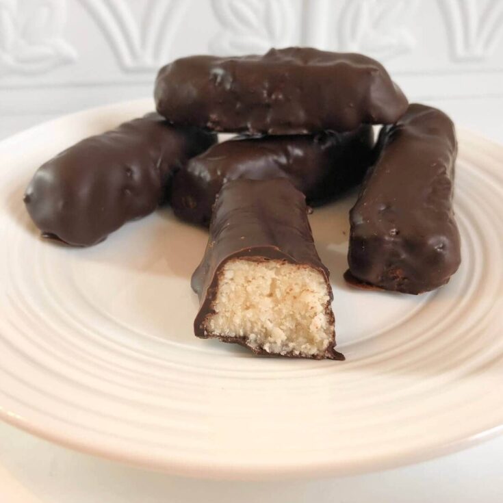 Vegan protein bars coated in chocolate on a white plate.