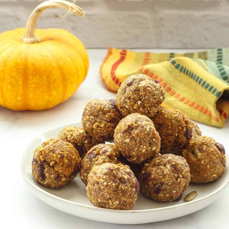 Vegan pumpkin energy bites with oats and chocolate chips on a white plate. Perfect healthy snack for.
