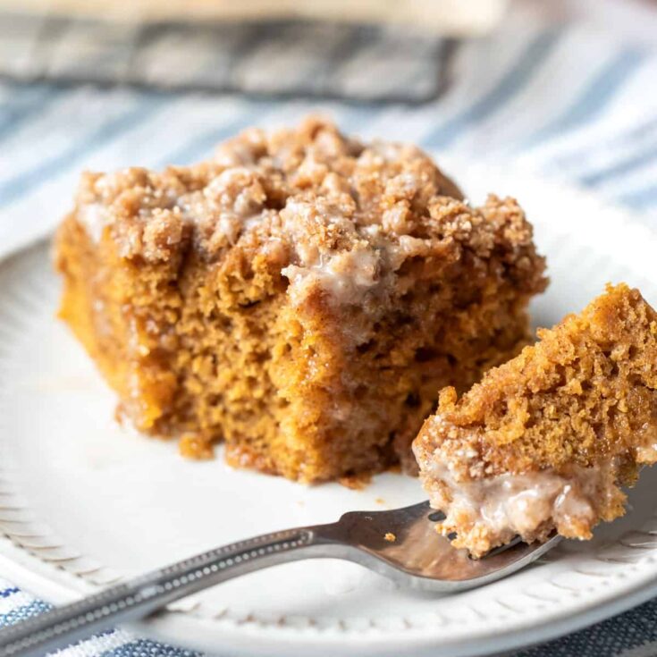 Delicious vegan pumpkin coffee cake with crumb topping on a white plate.