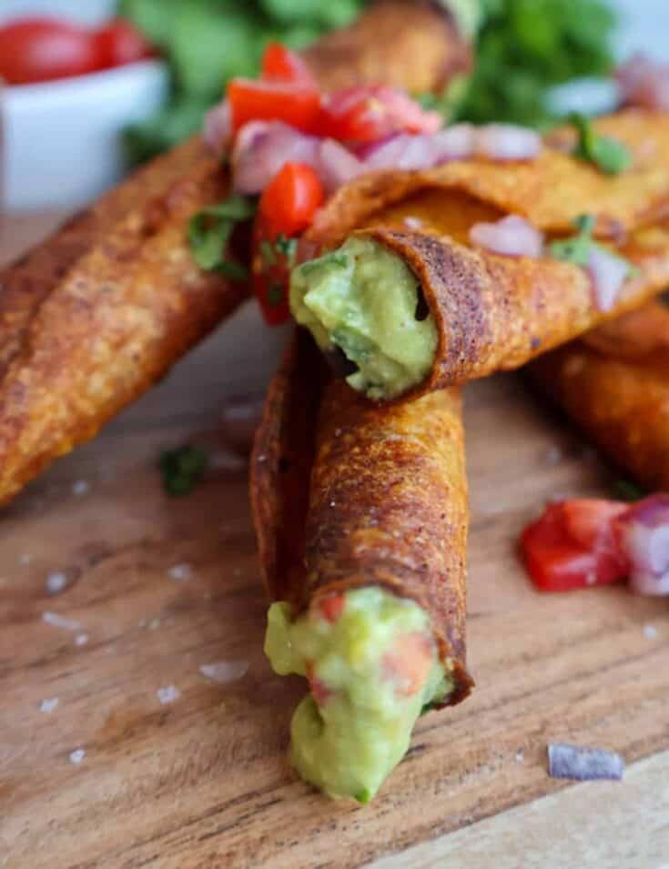 Crispy vegan spring rolls filled with creamy guacamole and fresh vegetables.
